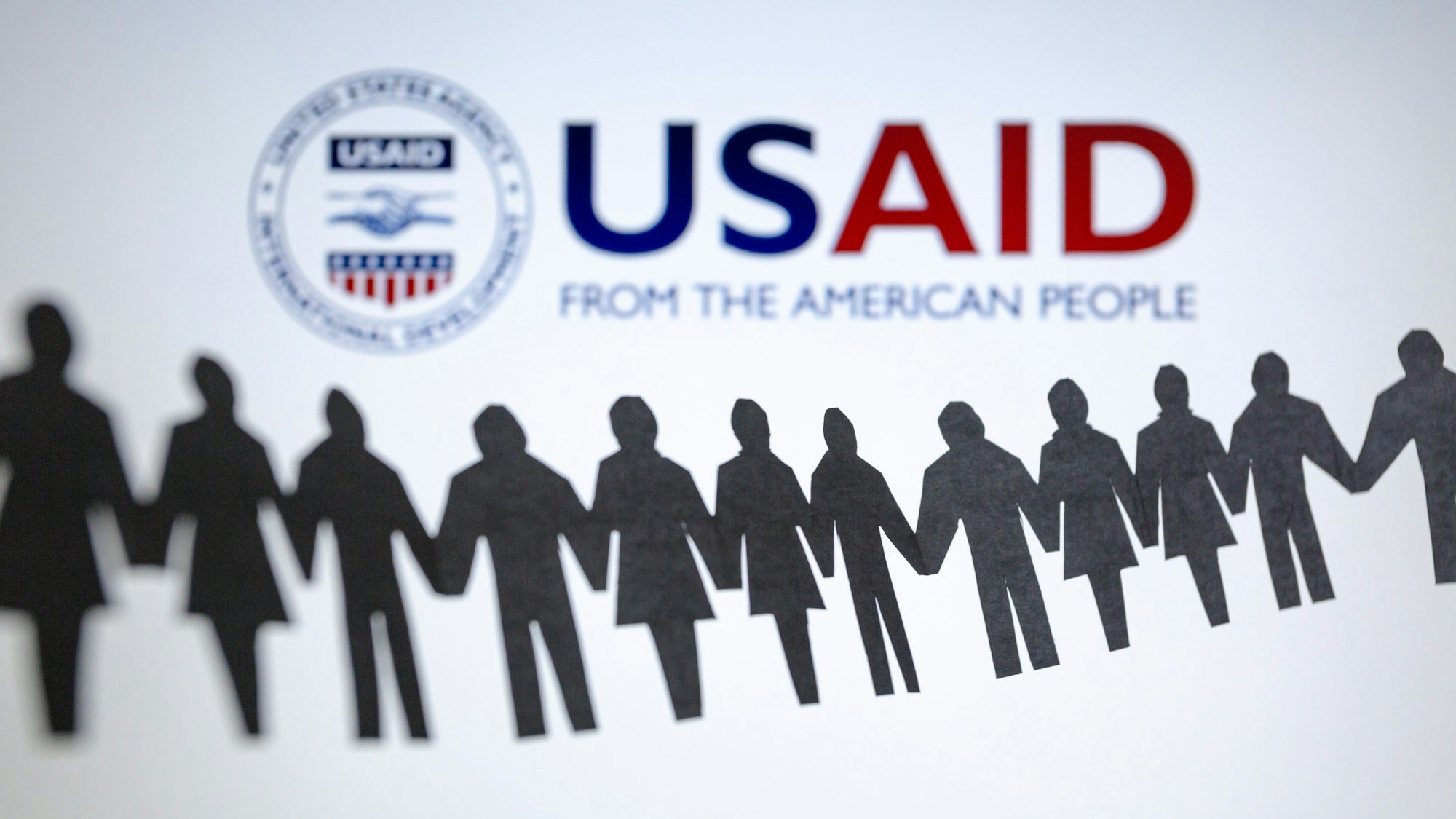 Das Logo der US-Entwicklungsbehörde, United States Agency for International Development (USAID), ist hinter einer Kette von ausgeschnittenen Papierfiguren zu sehen. (Archivbild)