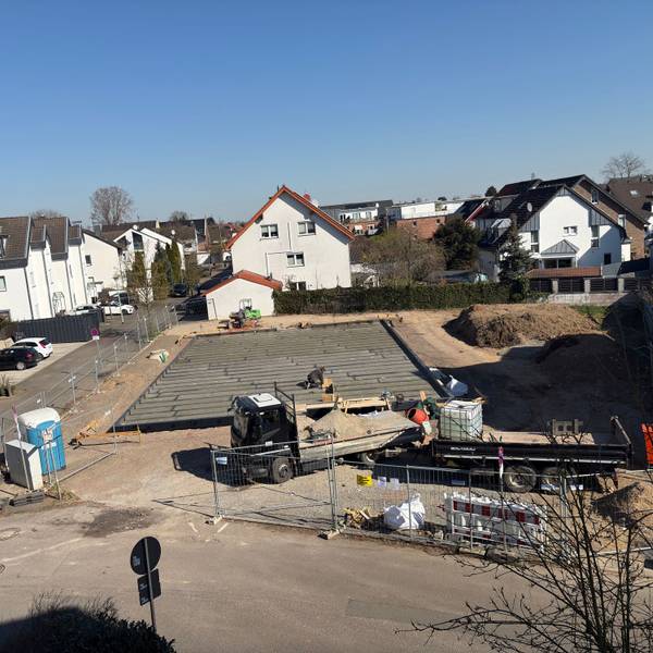 Eine Baustelle, im Hintergrund rechts liegt Bodenaushub.