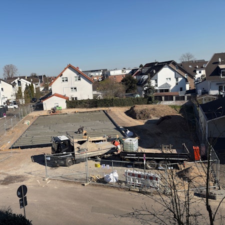 Eine Baustelle, im Hintergrund rechts liegt Bodenaushub.