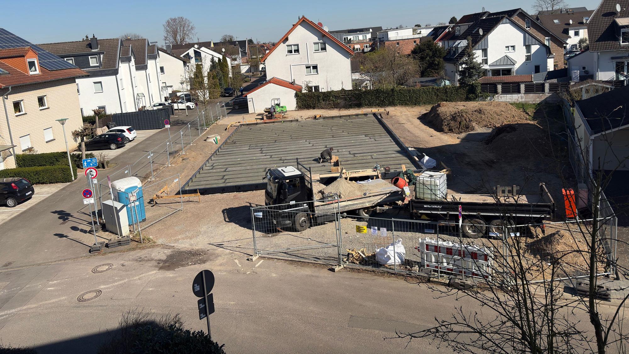 Eine Baustelle, im Hintergrund rechts liegt Bodenaushub.