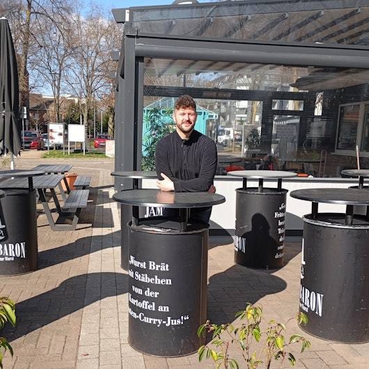 Das Foto zeigt Alexander Schebalkin vor seinem geschlossenen Kult-Imbiss „Wurst-Baron“ in Kerpen-Horrem.