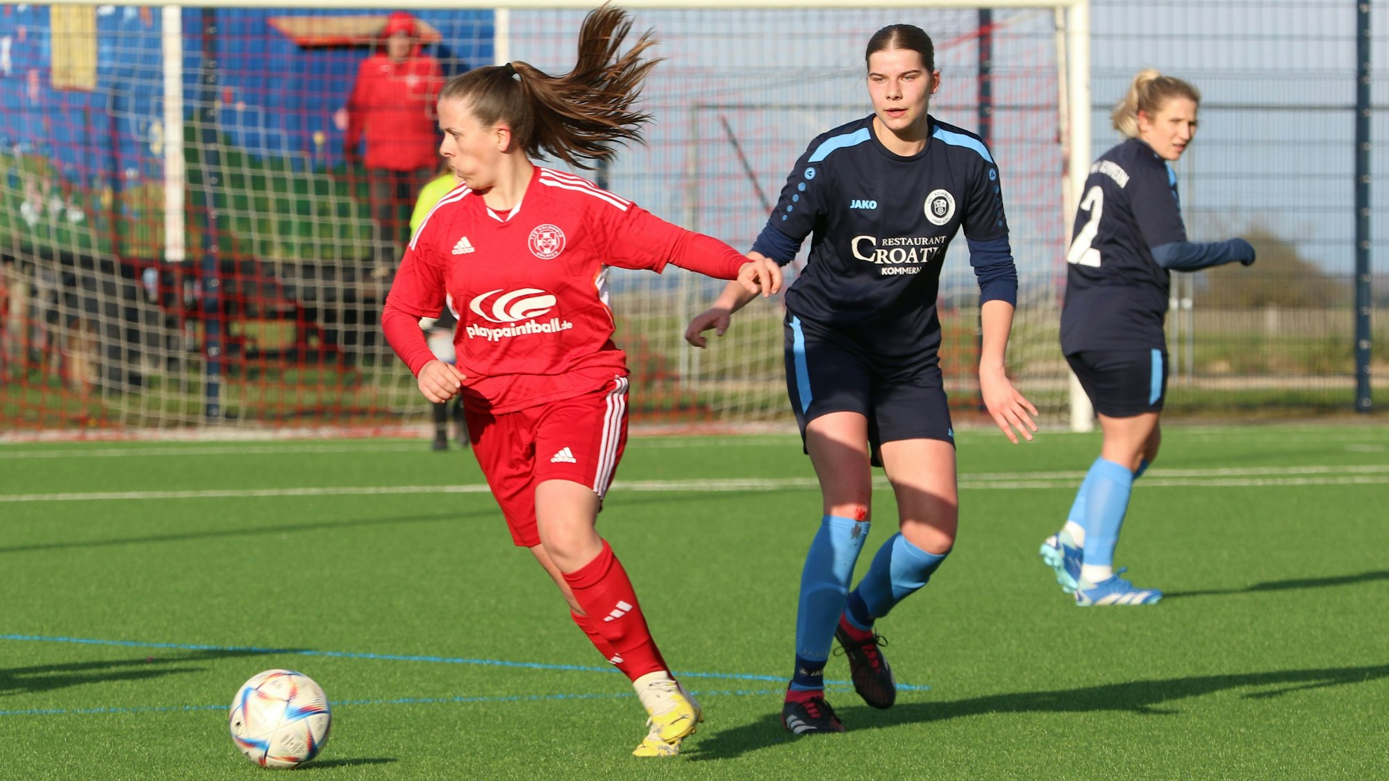 Die Fußballerin des TuS Zülpich ist am Ball, ihr Zopf fliegt durch die Luft.