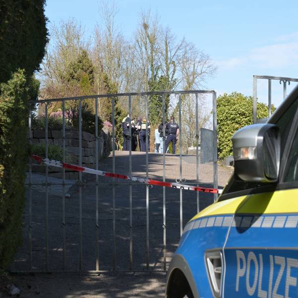 Ein Polizeiwagen steht vor dem Tor des Volbergerer Friedhofs, Flatterband versperrt den Zugang.