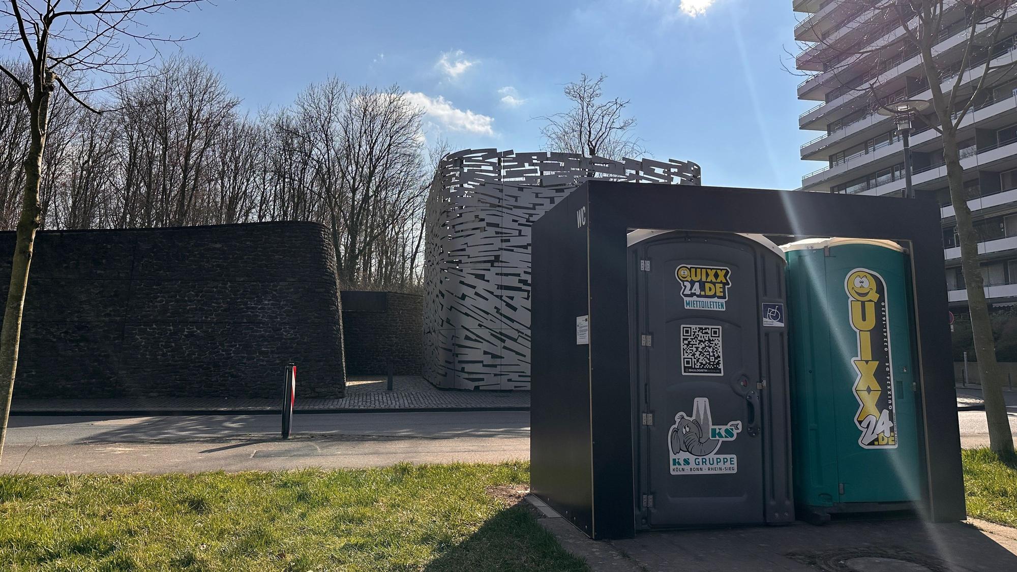 Vor einem Hochwasserpumpwerk in Rodenkirchen steht ein mobiles Toilettenhäuschen.