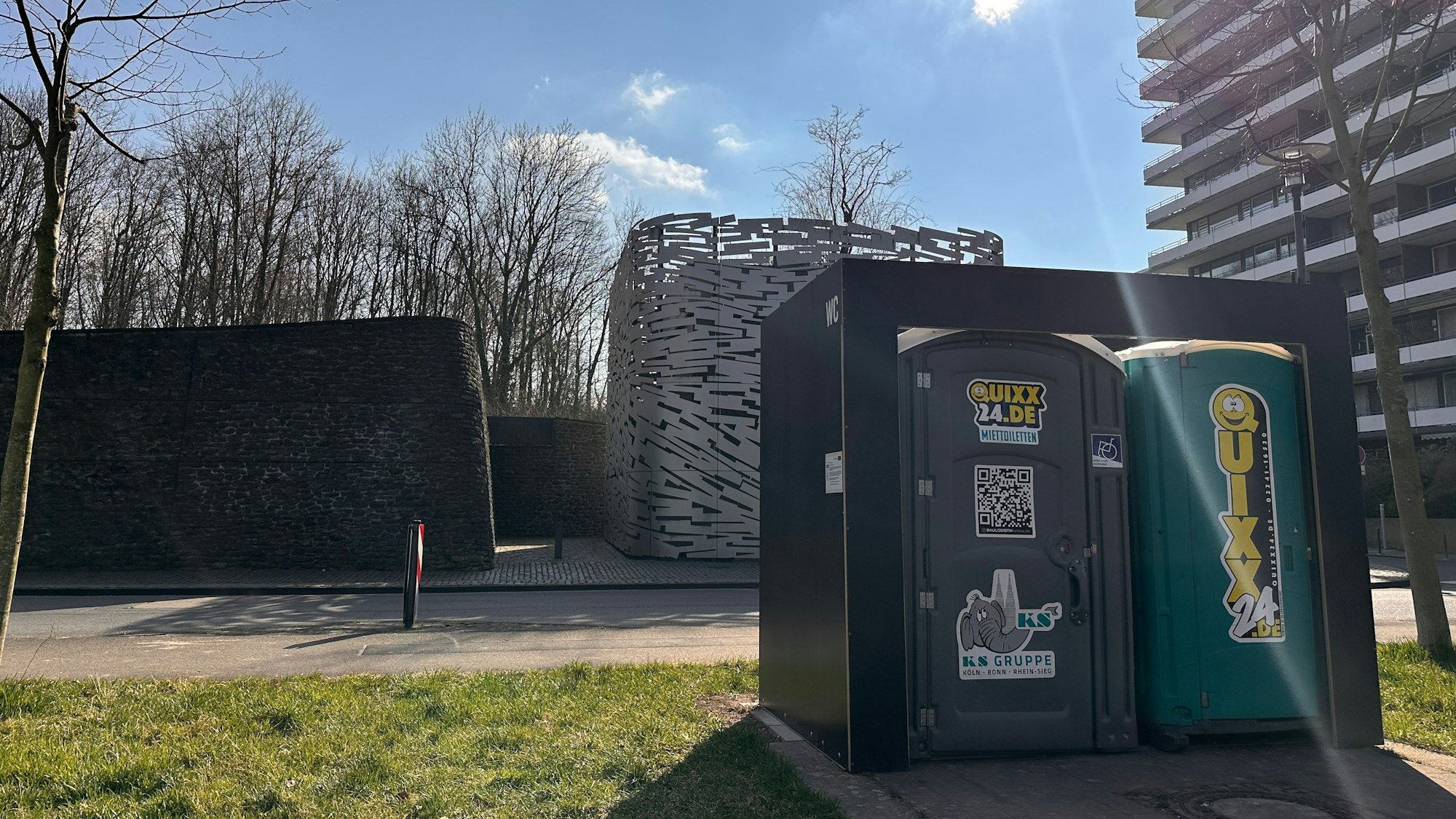 Vor einem Hochwasserpumpwerk in Rodenkirchen steht ein mobiles Toilettenhäuschen.