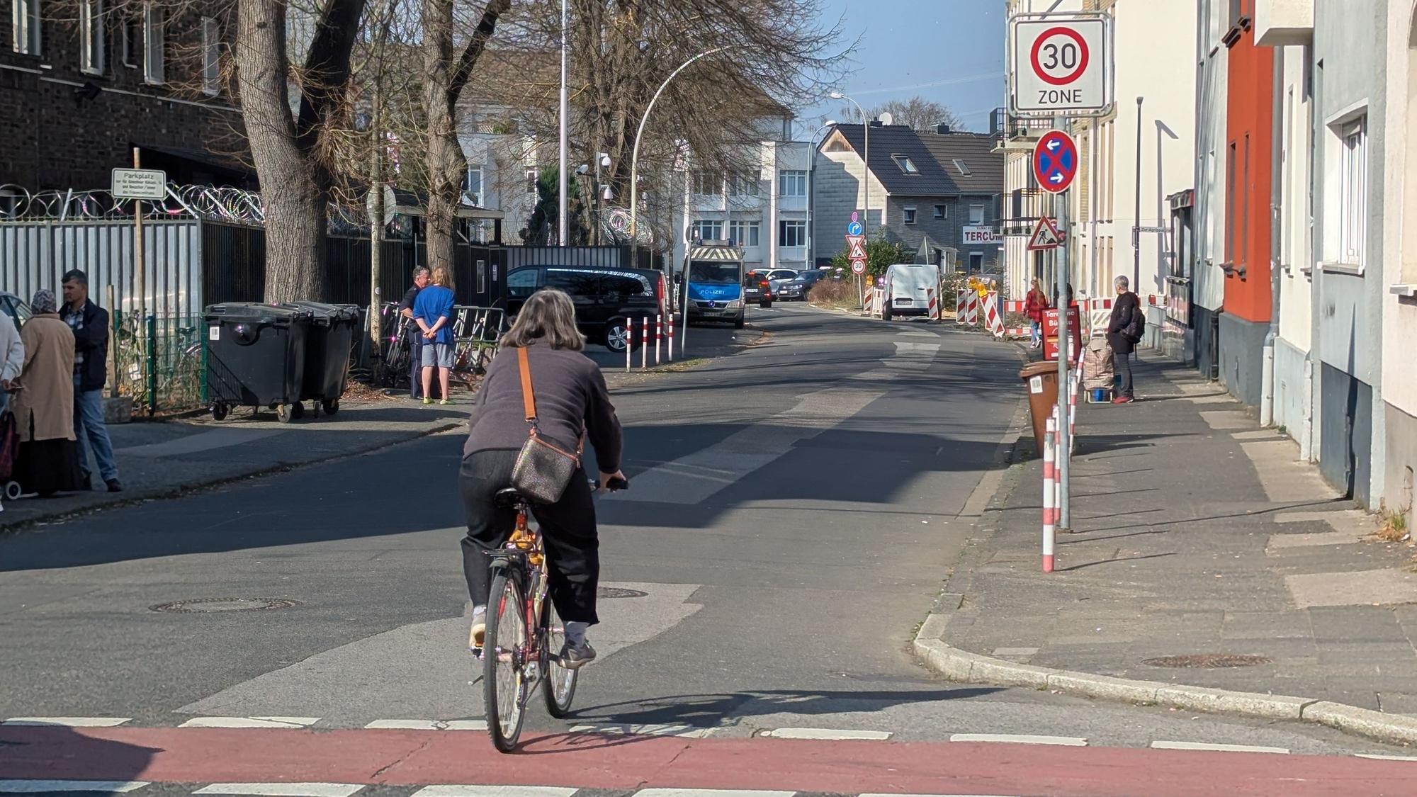 Das Foto zeigt den betroffenen Abschnitt der Kölnstraße, im Vordergrund eine Radfahrerin.