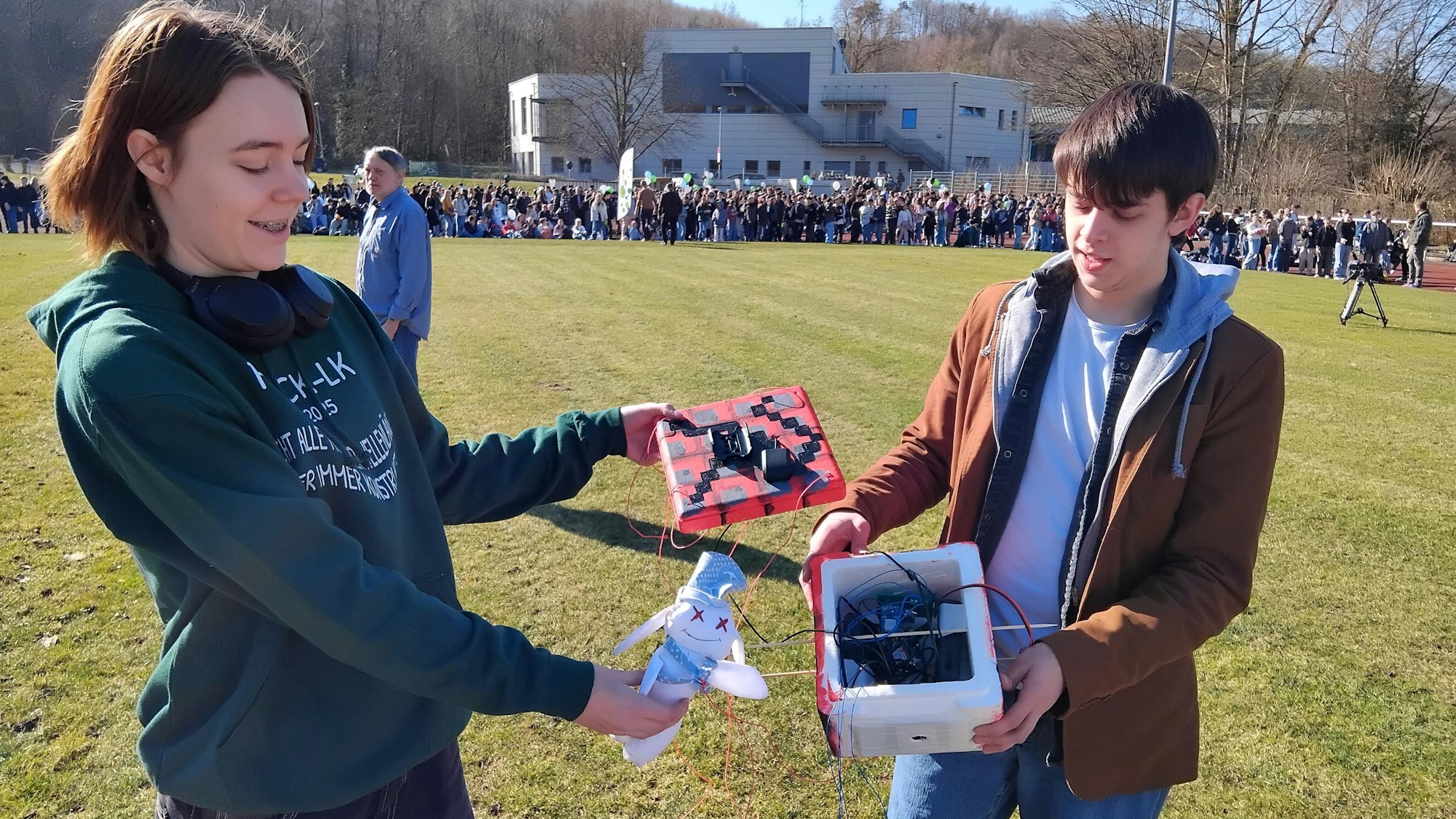 Eine Schülerin und ein Schüler zeigen die Technik des Wetterballons