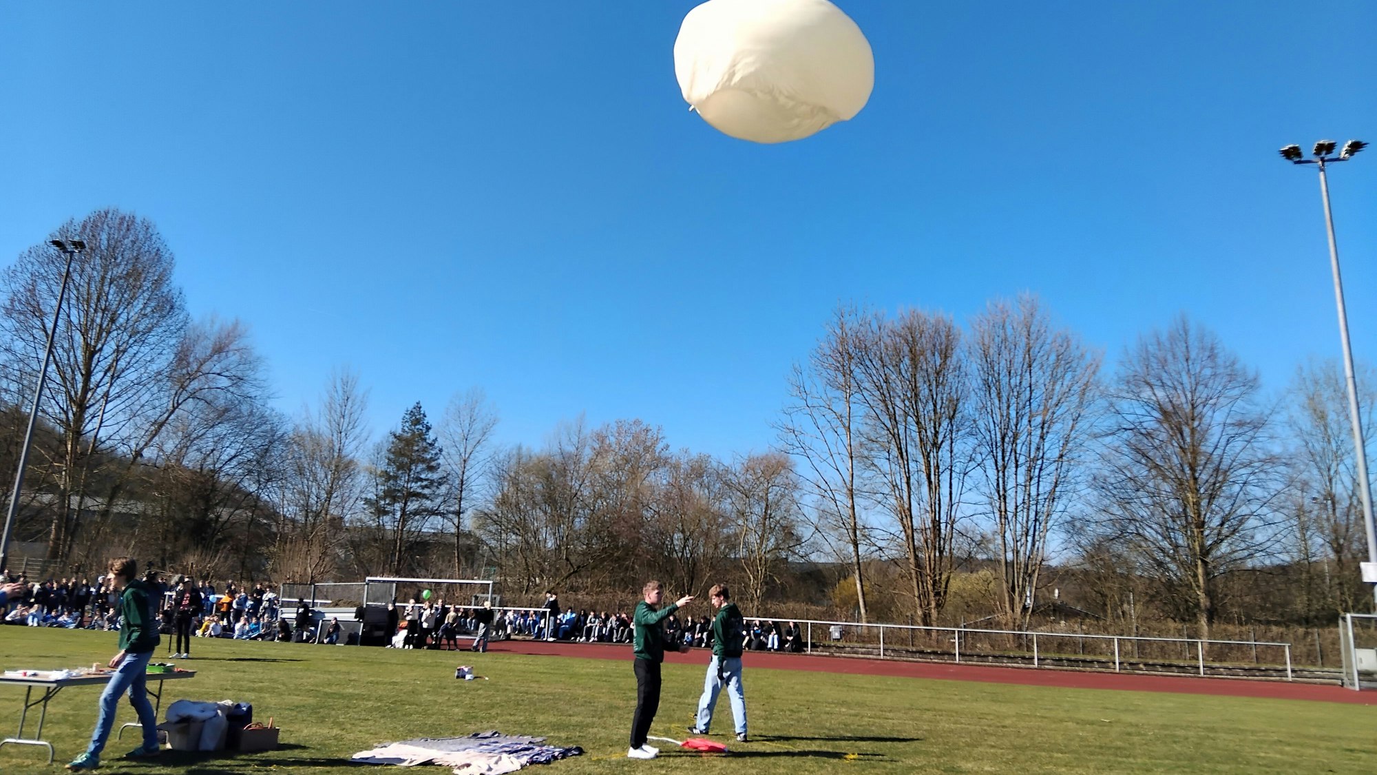 Schüler lassen auf dem Sportplatz einen Wetterballon starten
