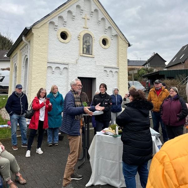 Menschen stehen vor einer Kapelle