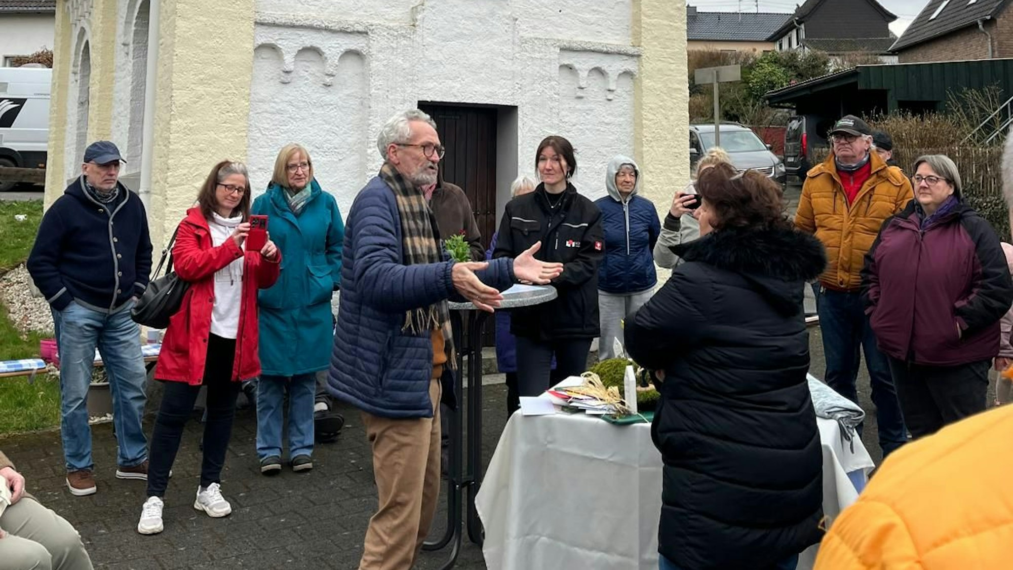Menschen stehen vor einer Kapelle