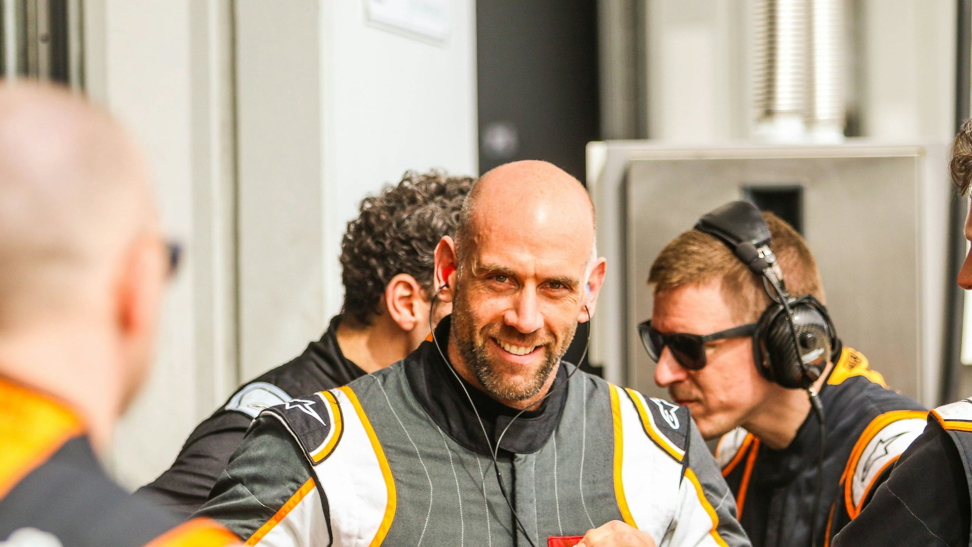 Danny Kubasik in der Boxengasse. Er trägt einen Rennoverall, aber keinen Helm.