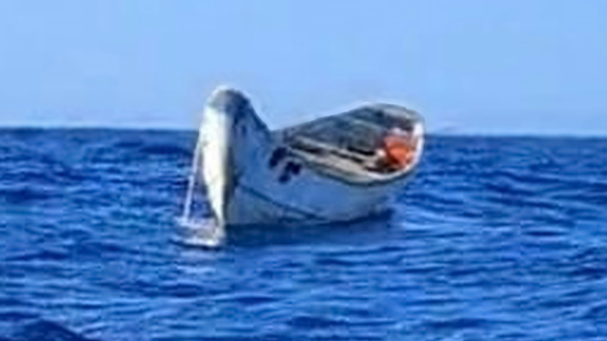 Die absichtlich unscharf gestellte Aufnahme zeigt ein Holzboot auf offener See.
