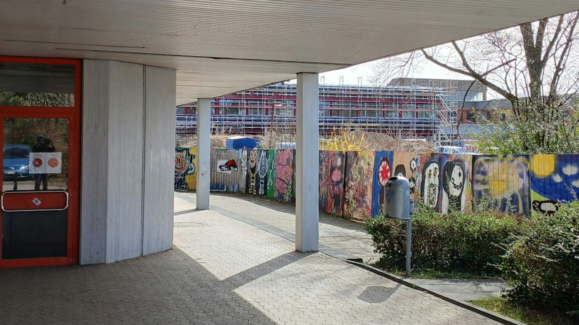 Ein Schulgebäude, im Hintergrund eine Baustelle.