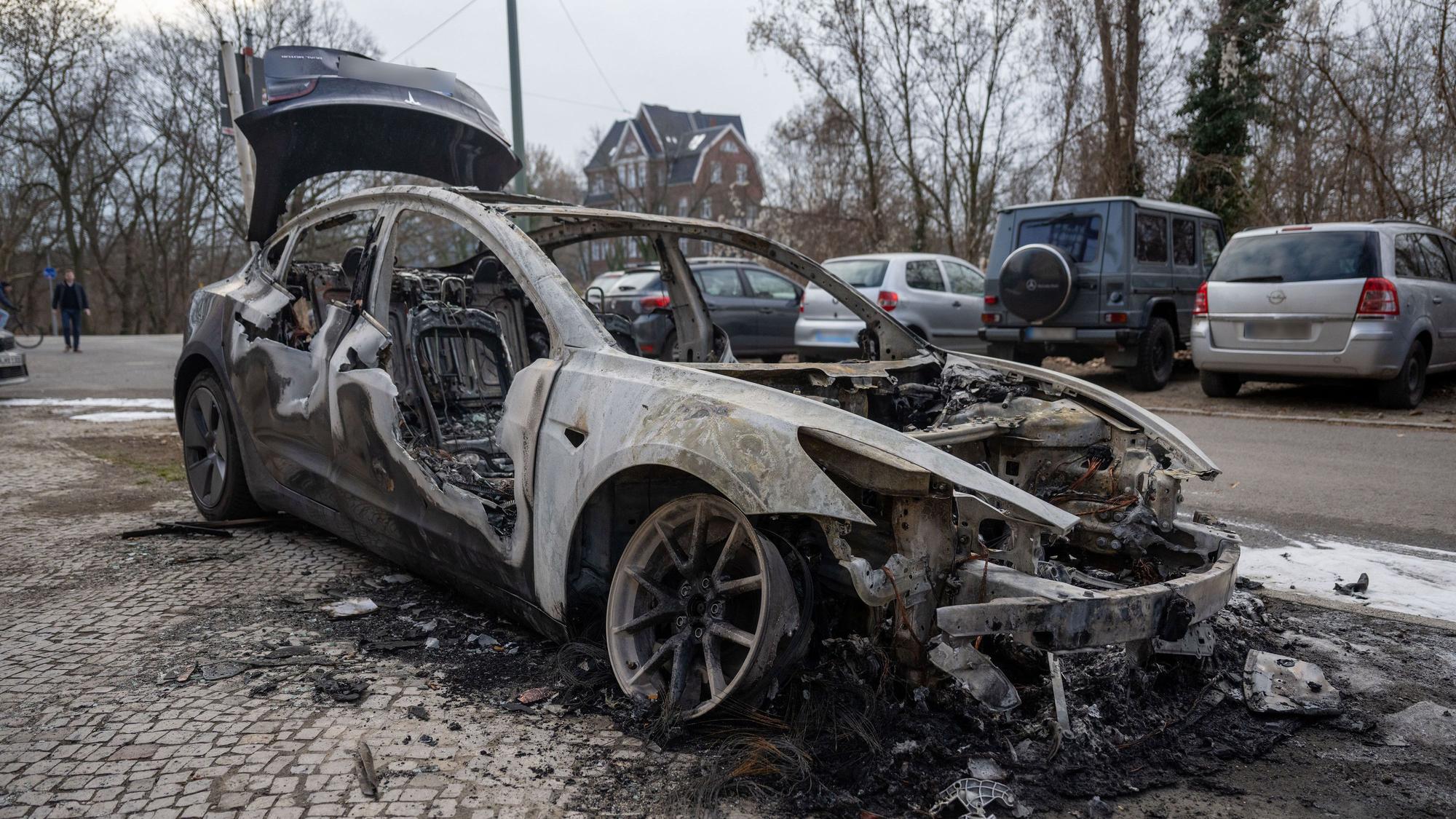 Im Berliner Stadtteil Steglitz steht ein ausgebranntes Auto der Marke Tesla. Vier Teslas sind in der Vorwoche in Berlin mutmaßlich angezündet worden. (Archivbild)