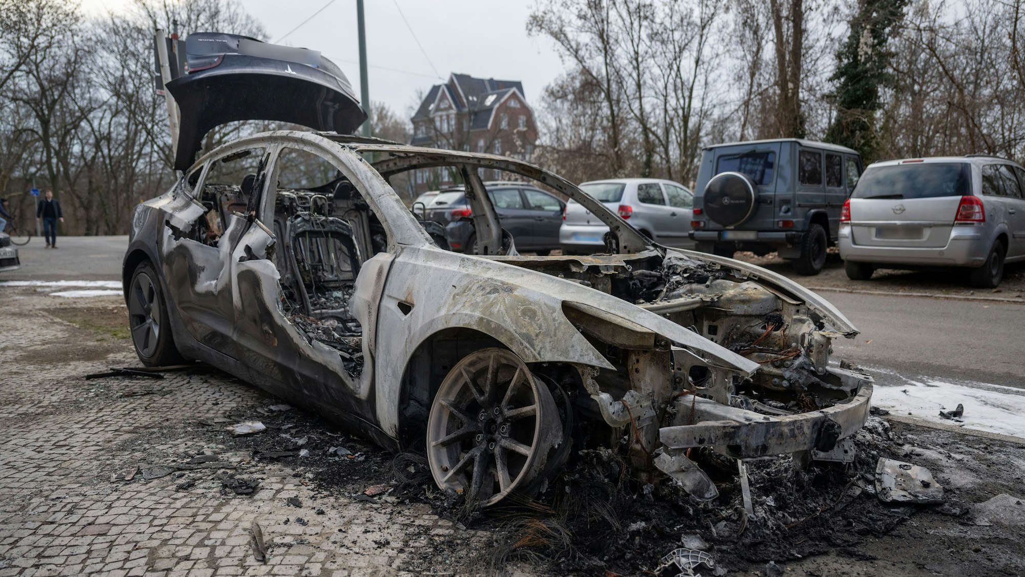 Im Berliner Stadtteil Steglitz steht ein ausgebranntes Auto der Marke Tesla. Vier Teslas sind in der Vorwoche in Berlin mutmaßlich angezündet worden. (Archivbild)