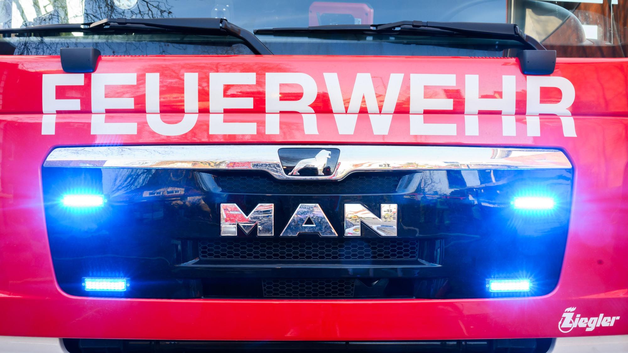 Blaulichter leuchten an einer Einsatzstelle an einem Löschfahrzeug der Feuerwehr.