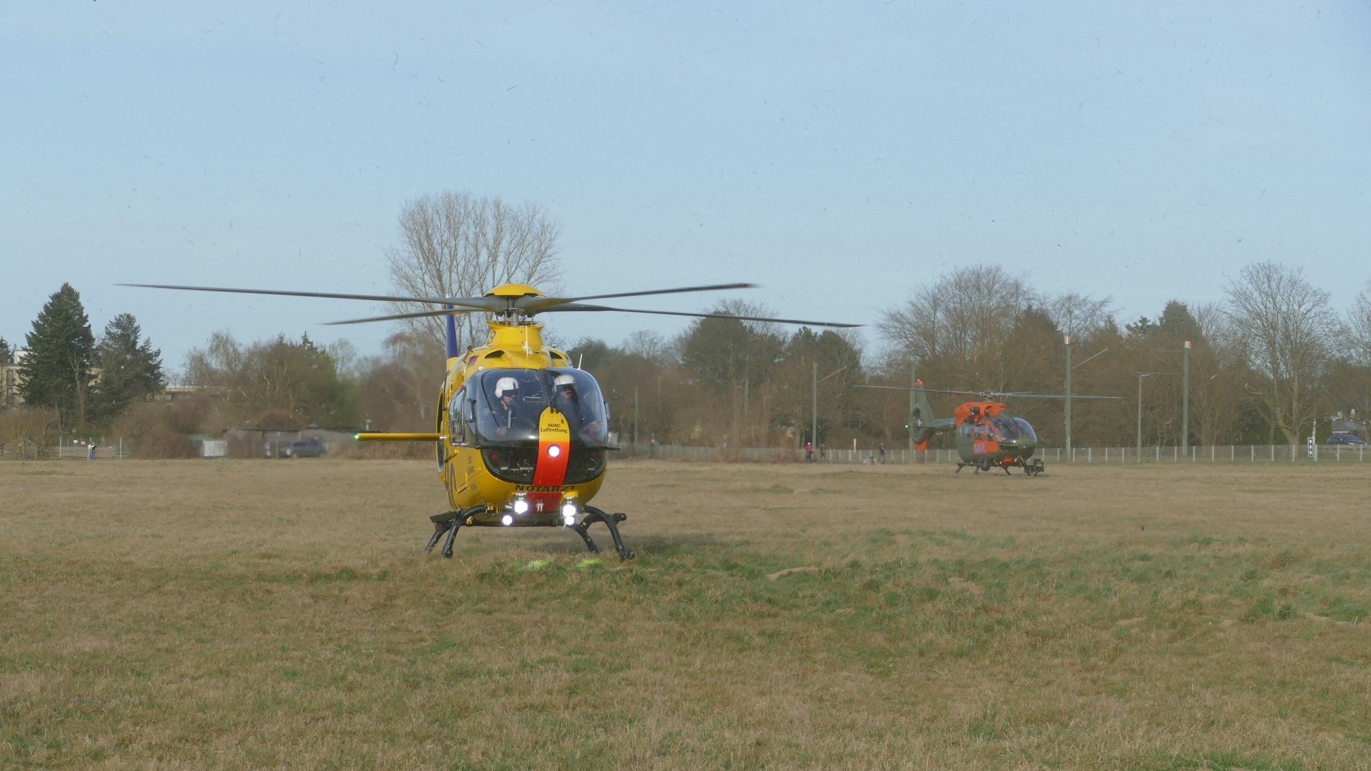Zwei Hubschrauber stehen auf einem Feld.