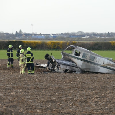 Einsatzkräfte stehen neben einem Flugzeugwrack auf einem Feld in Sankt Augustin.