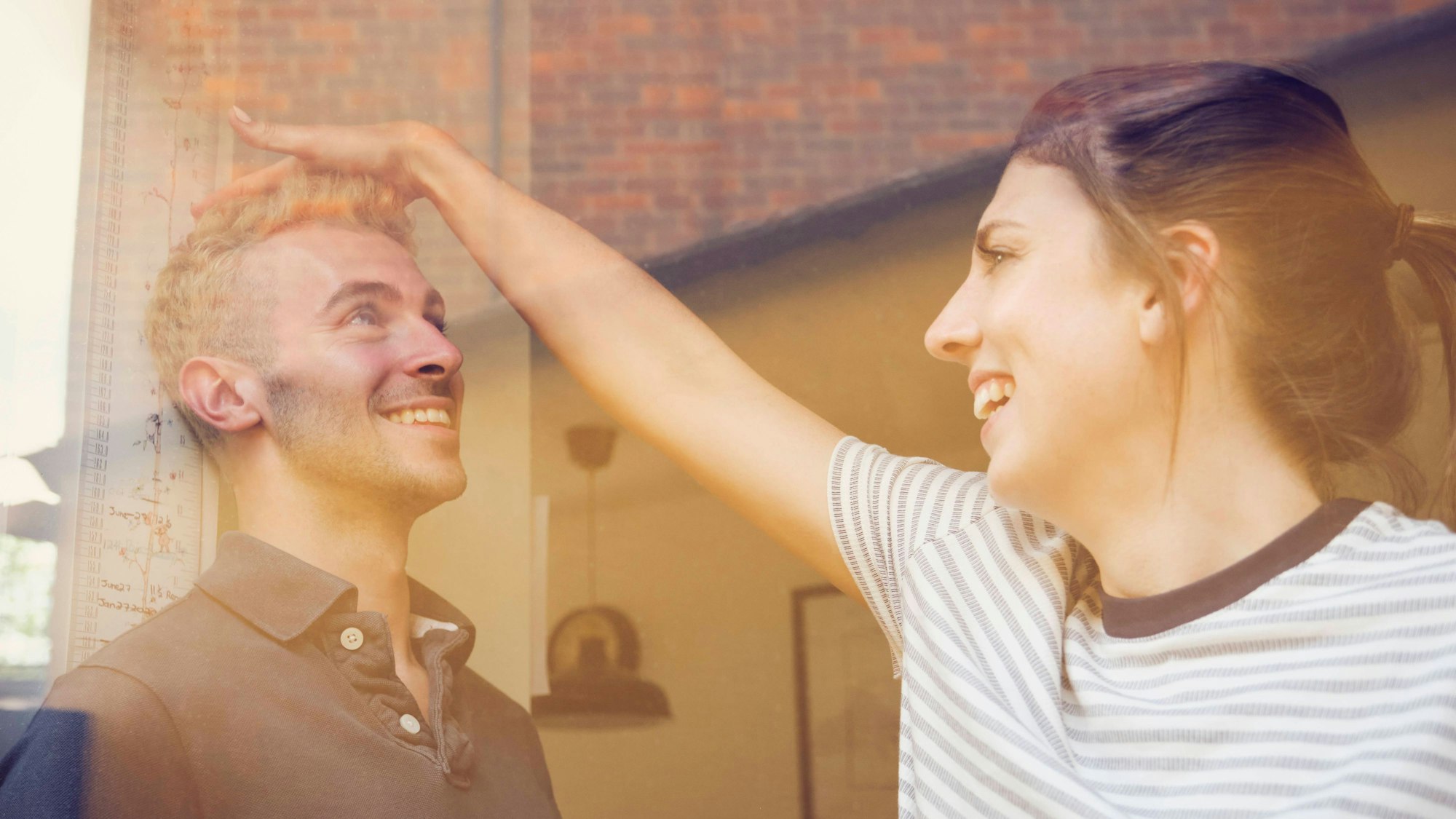 Eine Frau misst die Körpergröße eines Mannes.