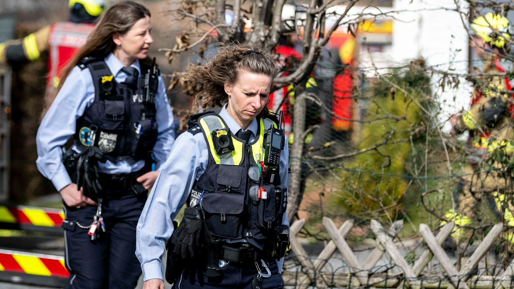 Das Bild zeigt zwei Polizeibeamtinnen, die die Einsatzstelle verlassen.