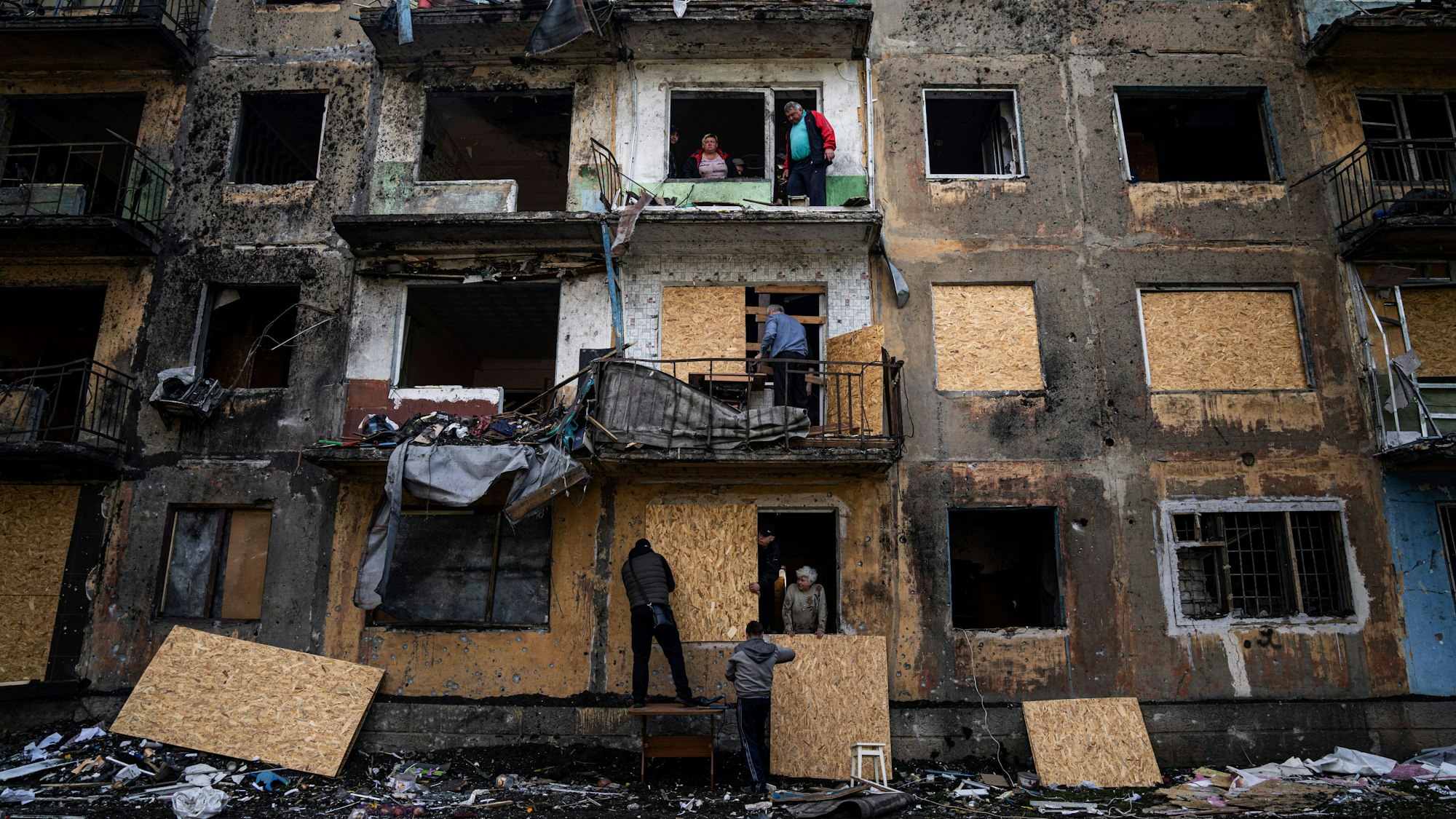 Anwohner schließen die Fenster eines Wohnhauses mit Sperrholz nach russischem Beschuss in Dobropillja in der Region Donezk in der Ostukraine.