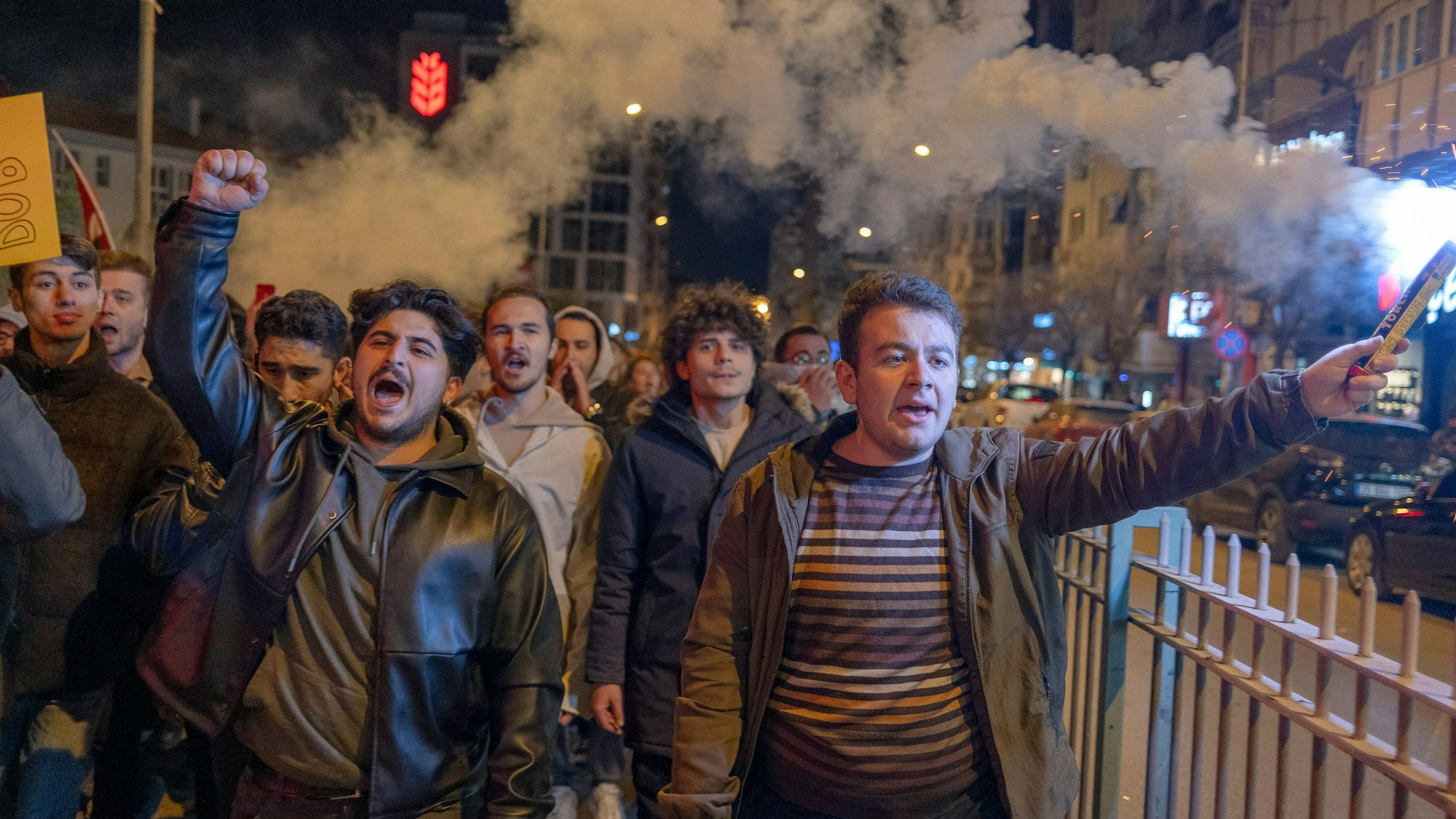Türkei, Izmir: Menschen halten Rauchfakeln und protestieren nach der Festnahme des Istanbuler Bürgermeisters Imamoglu.