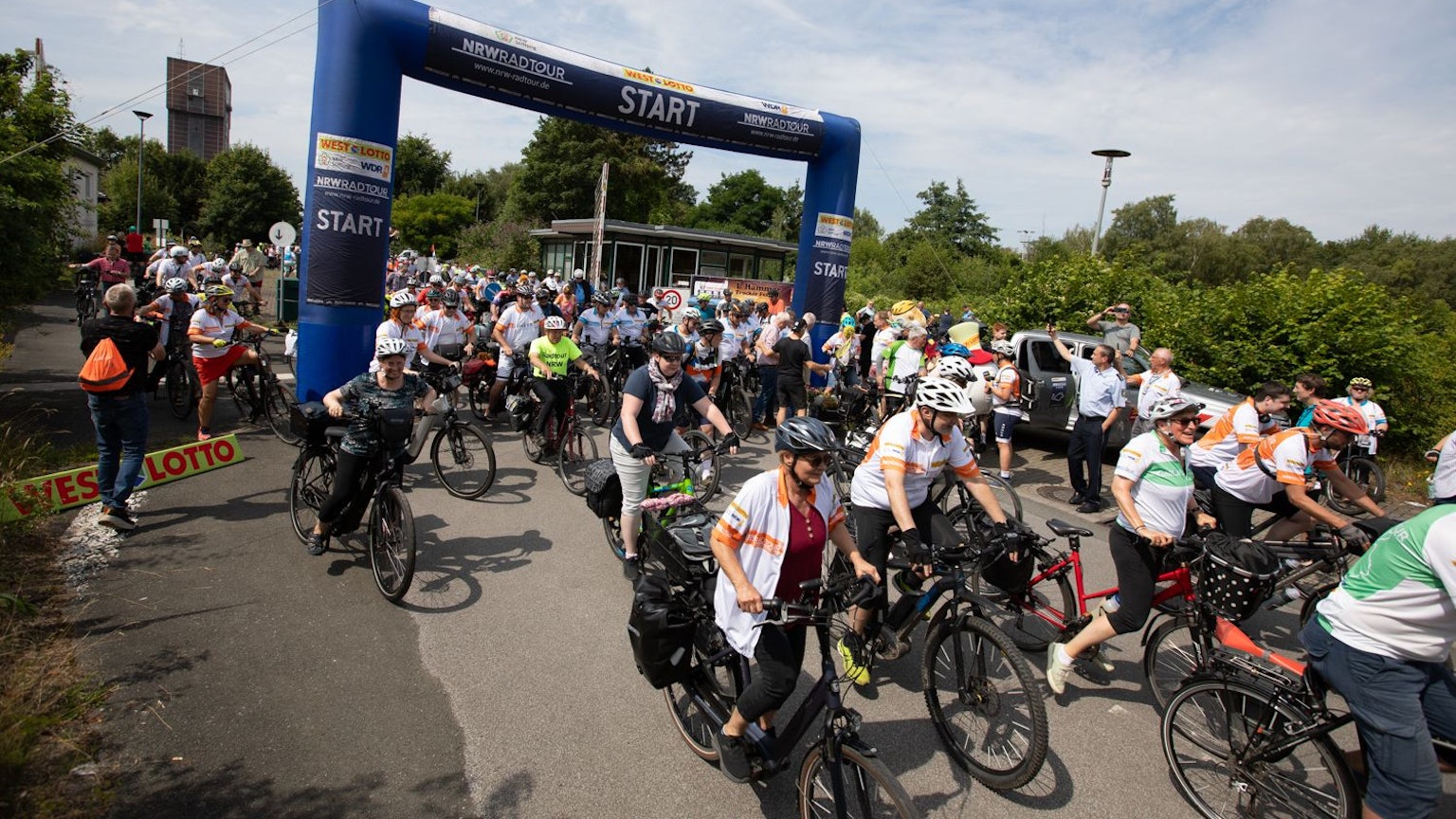Die NRW-Radtour 2025 startet am 17. Juli in Leverkusen. Gemeinsam wird auf rund 220 Kilometer über die Etappenziele Köln – mit einer Doppelübernachtung – und Neuss zum Ausgangspunkt zurück nach Leverkusen geradelt. Anmeldungen für das vier Tage Event sind in allen WestLotto-Annahmestellen oder unter www.nrw-radtour.de möglich.