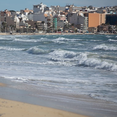 Eine Frau spaziert an einem windigen Tag am Strand von Arenal auf Mallorca entlang. In einigen Fällen wurden die Leichen von Passanten entdeckt. (Archivbild)