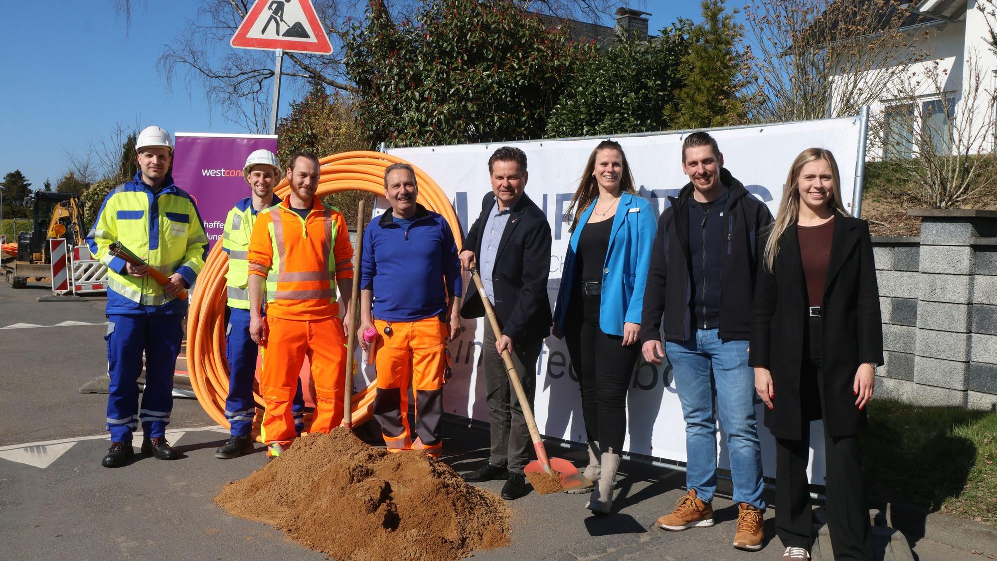 Mehrere Menschen stehen an einem Baufeld.