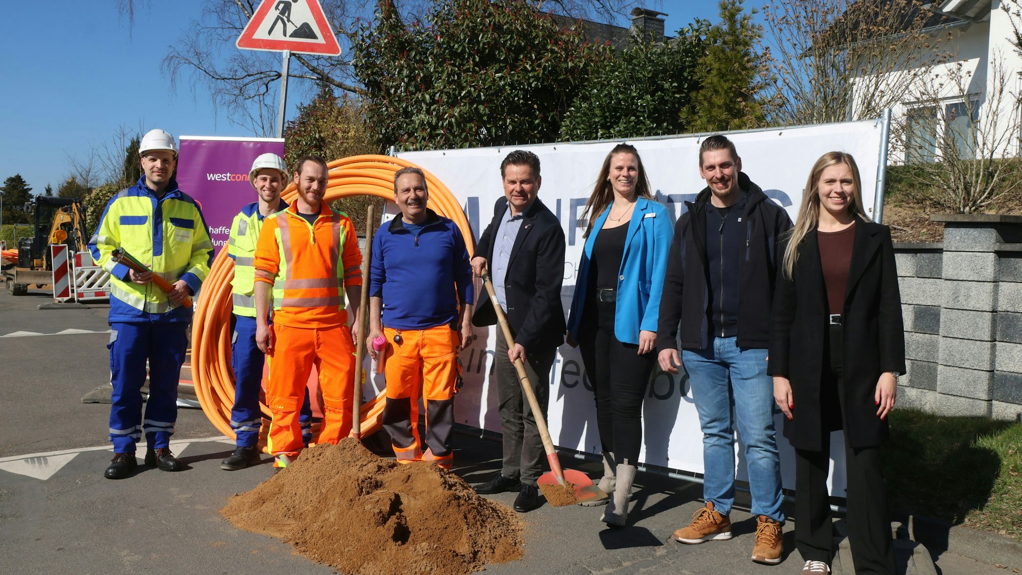 Mehrere Menschen stehen an einem Baufeld.