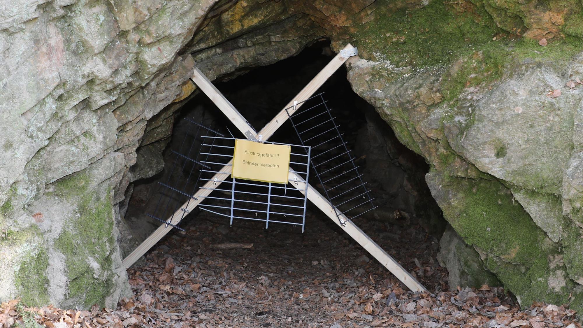Ein Verschlag aus Latten und Gittern sperrt den Eingang zur sogenannten Bärenhöhle in Bergisch Gladbach.