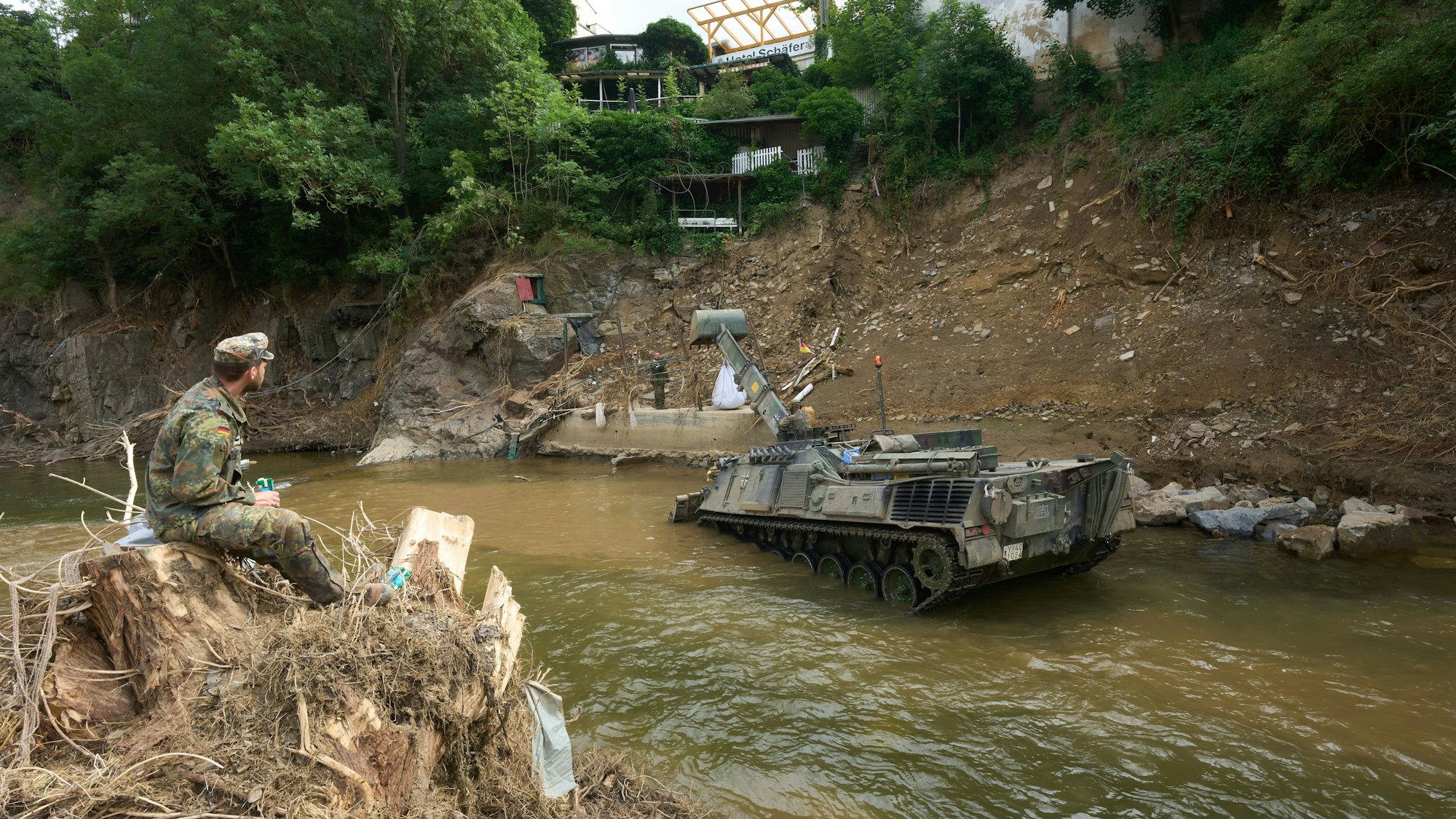 Mit einem Räumpanzer versuchen Bundeswehrsoldaten, einen abgerutschten Hang zu sichern.