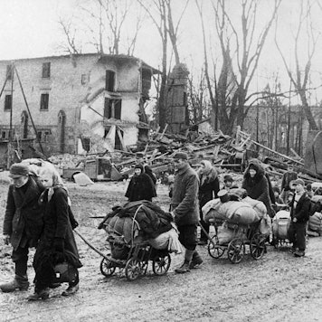 Ein Flüchtlingstreck, viele Menschen mit ihren Habseligkeiten auf Handwagen