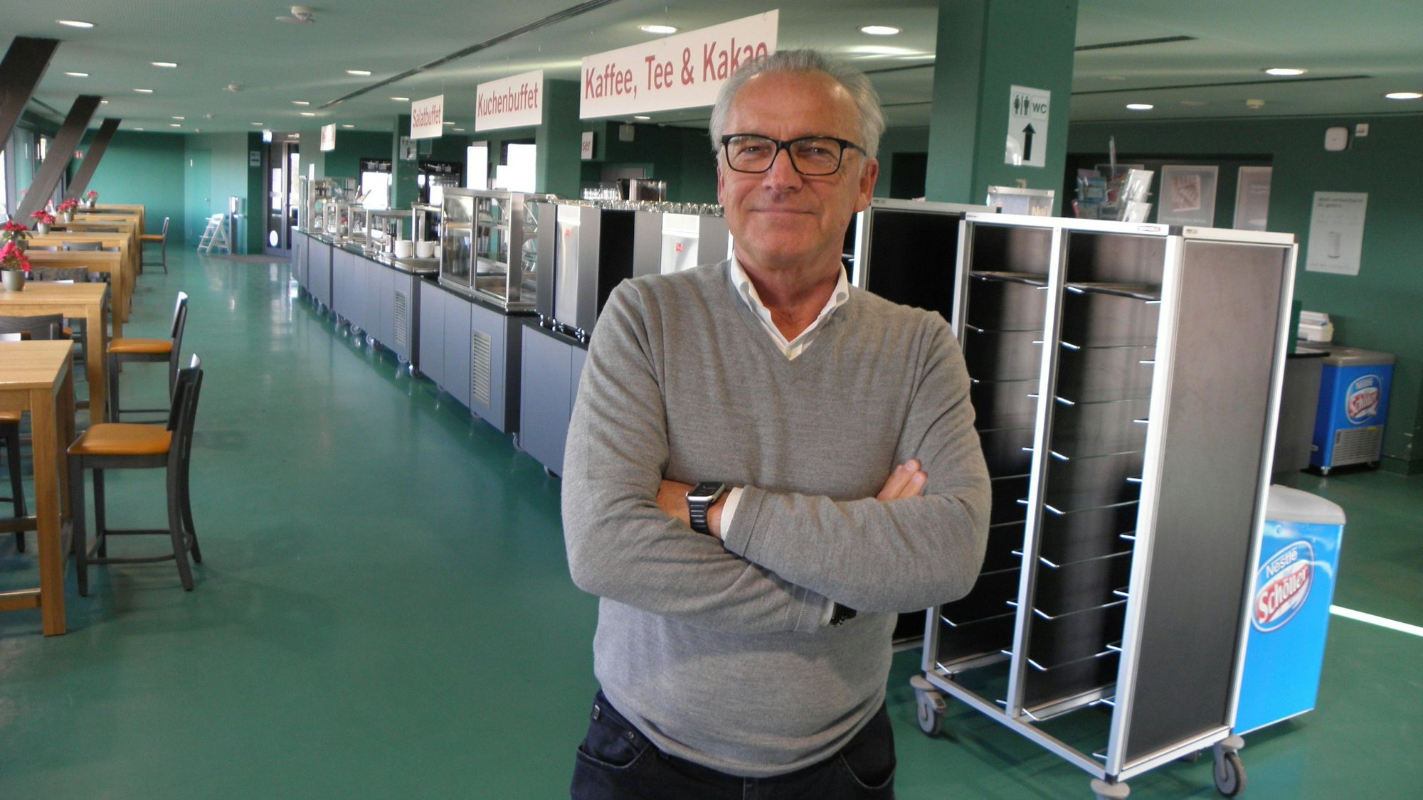 Hannes Pum steht mit verschränkten Armen in der Gastronomie von Vogelsang.