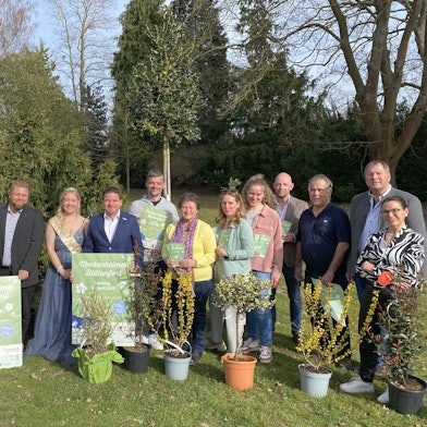 Veranstalter, Blütenkönigin und Bürgermeister stehen nebeneinander bei der Programmvorstellung.