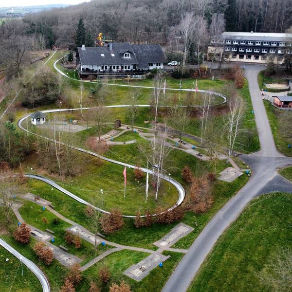 Die Drohnenaufnahme zeigt die Sommerrodelbahn und am oberen Bildrand Hotel und Restaurant.