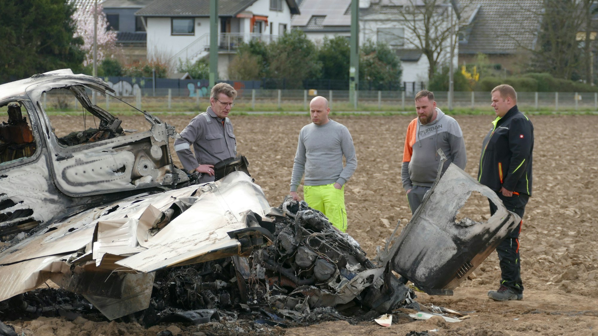 Mitarbeiter eines Abschleppunternehmens und des BFU begutachten das Flugzeugwrack am Flugplatz in Sankt Augustin-Hangelar.