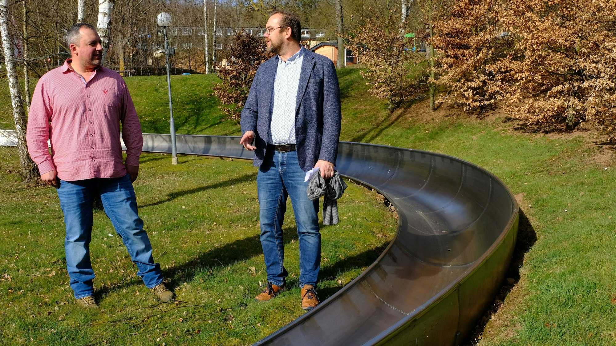 Christian Klein und Thomas Hambach (Freizeit Mechernich GmbH) stehen an der Sommerrodelbahn der Erlebniswelt Eifeltor.