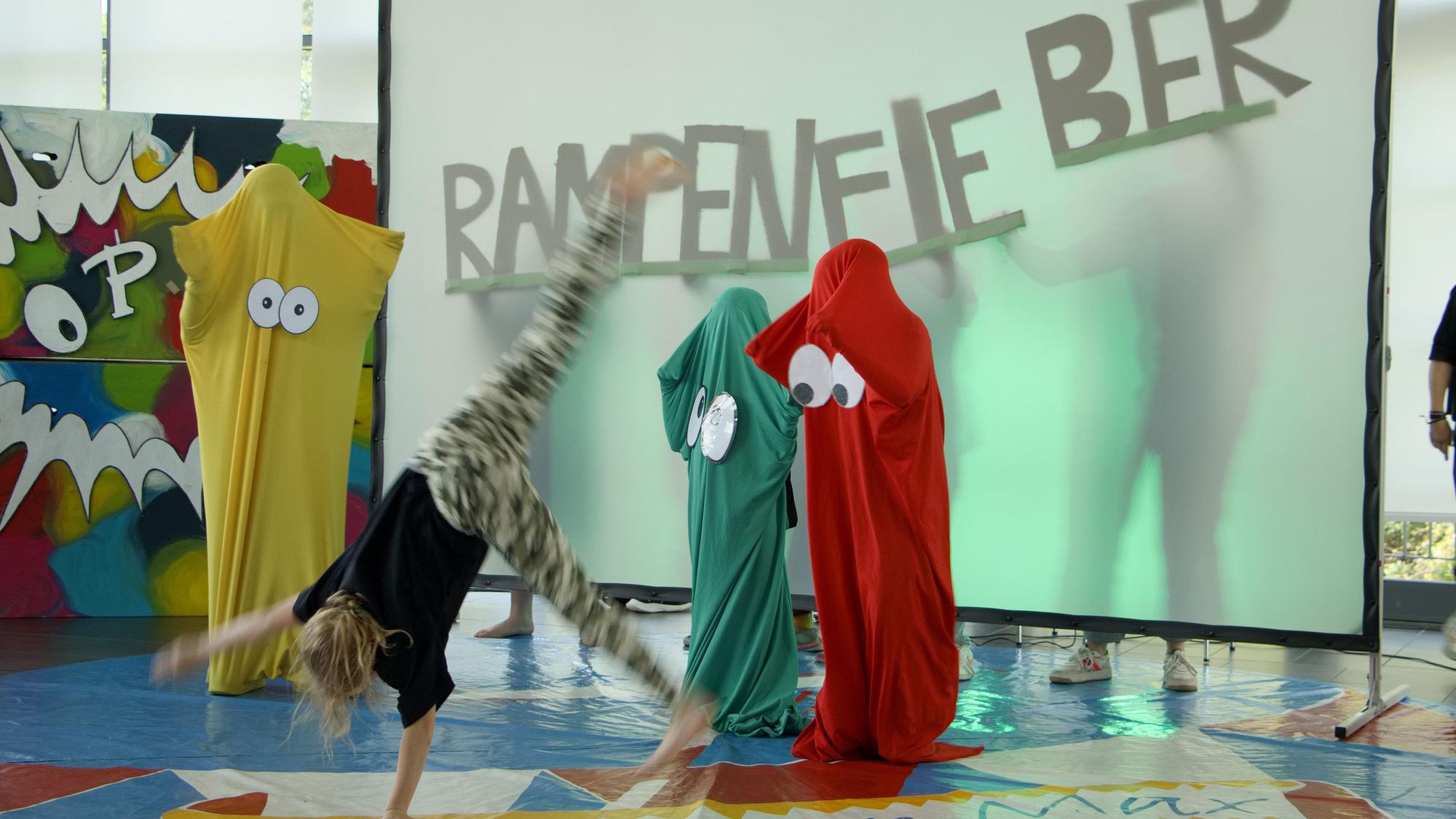 Das Bild zeigt einen Teil der Rampenfieber-Aufführung im vergangenen Jahr. Ein Kind schlägt gerade ein Rat vor kostümierten Kindern.