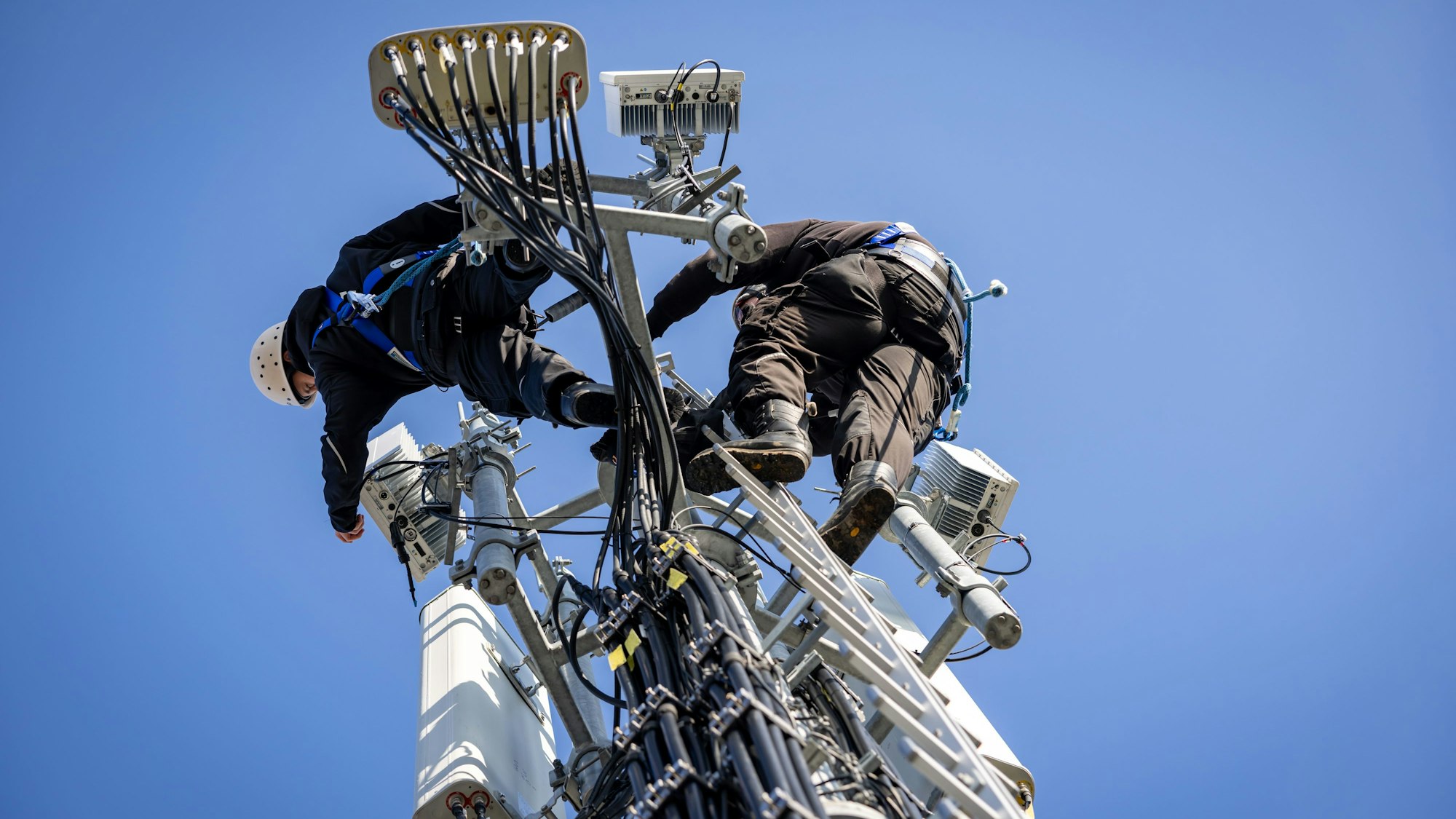 ARCHIV - 21.01.2025, Bayern, Nürnberg: Techniker der Deutschen Telekom führen an einem Mobilfunkmast eine Reparturarbeit an einer aktiven 5G-Antenne (3,6 Ghz) durch. (zu dpa: «Bundesnetzagentur möchte Handynetzausbau ankurbeln») Foto: Daniel Karmann/dpa +++ dpa-Bildfunk +++