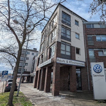 Das Foto zeigt das Wohn- und Geschäftshaus an der Luxemburger-, Ecke Bonnstraße, noch mit den alten Firmenschildern.