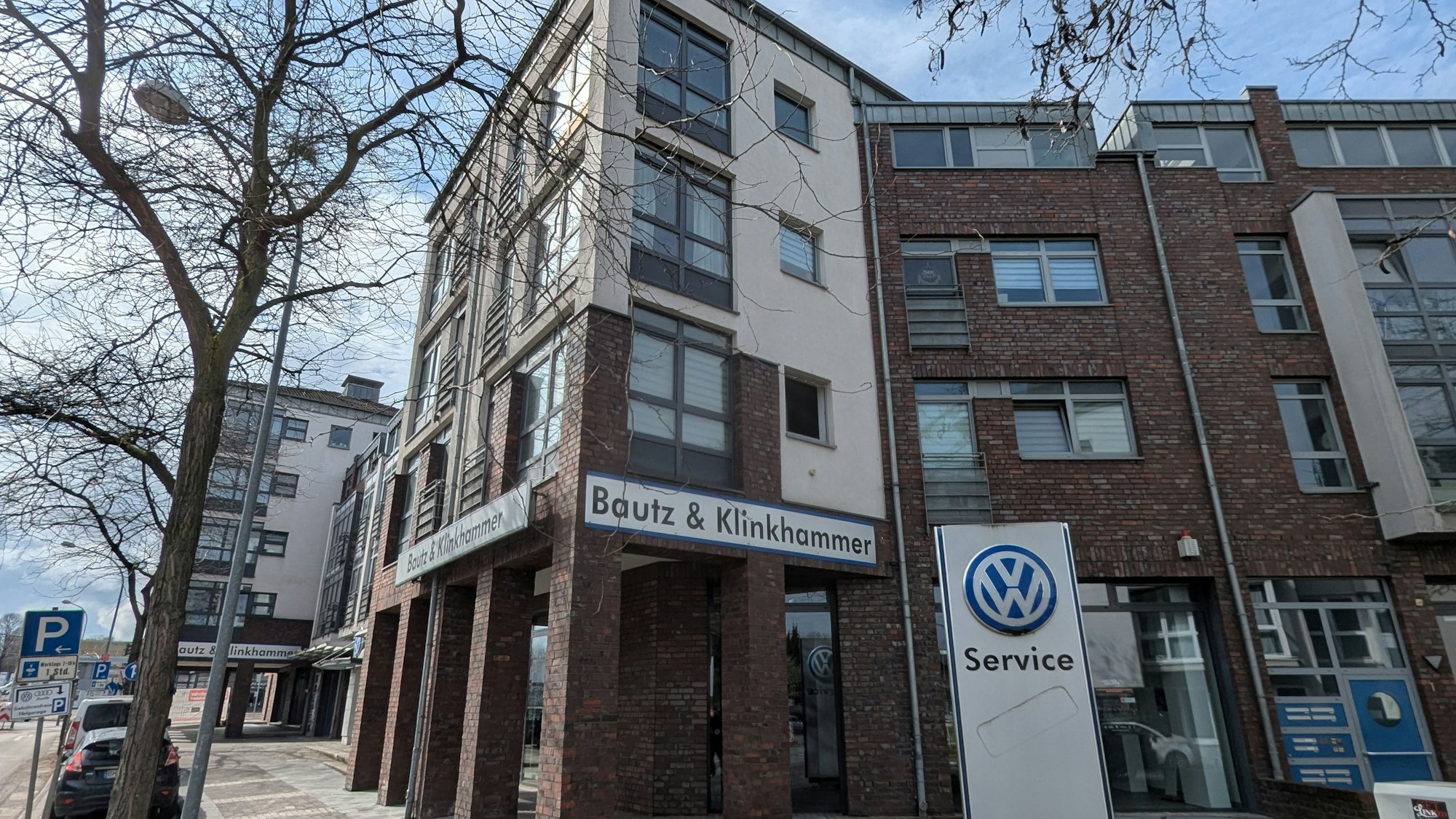 Das Foto zeigt das Wohn- und Geschäftshaus an der Luxemburger-, Ecke Bonnstraße, noch mit den alten Firmenschildern.