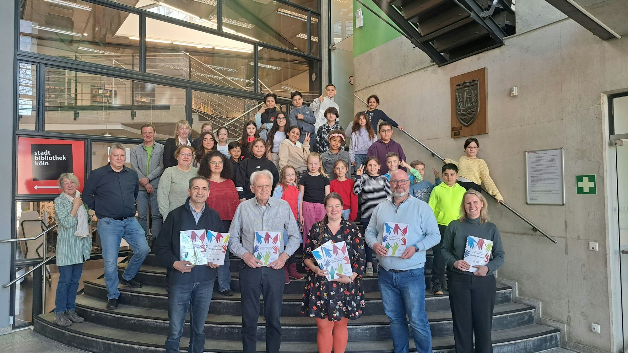 Kinder und Erwachsene stehen auf einer Treppe.
