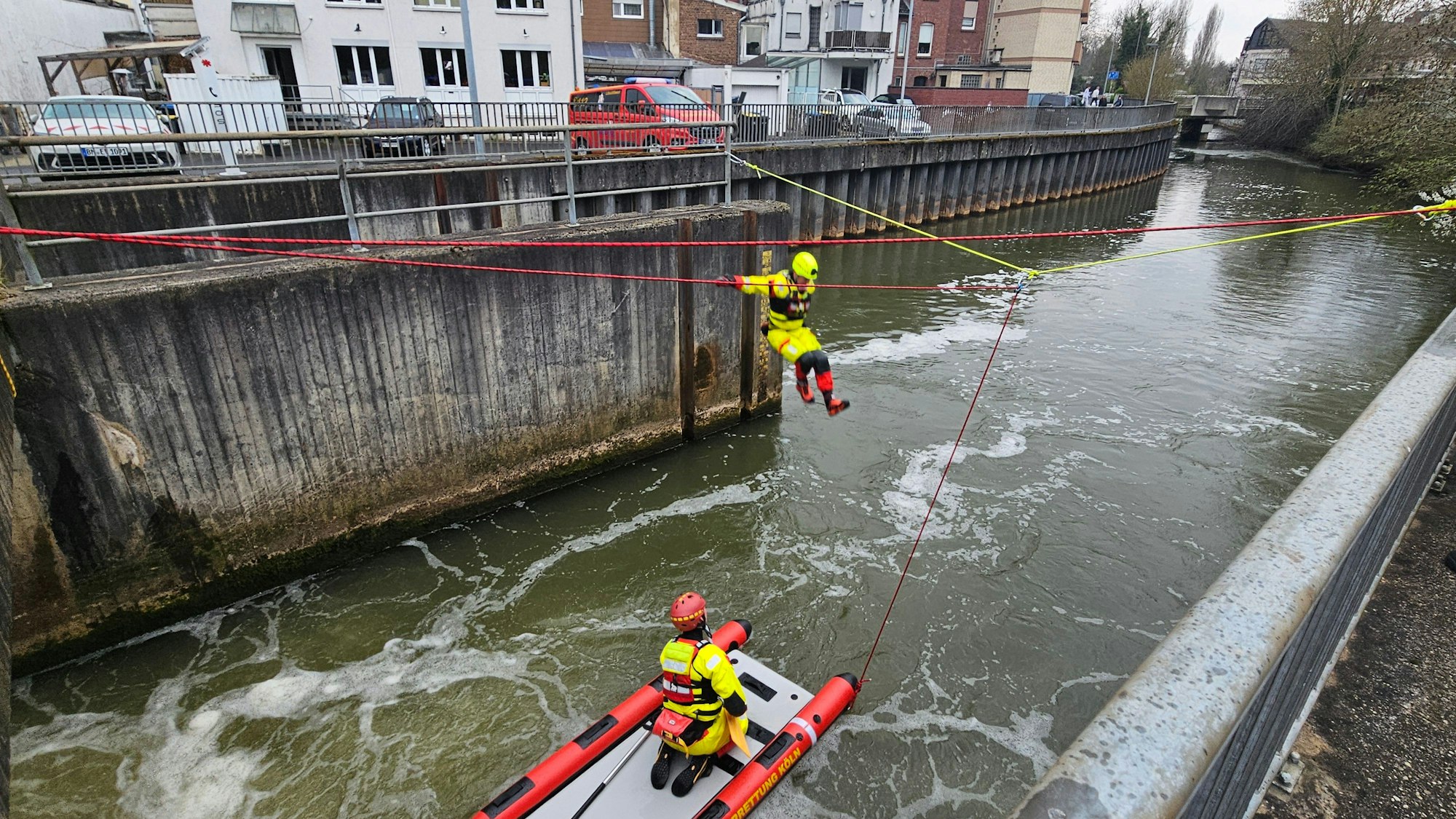 Zu sehen ist ein Strömungsretter der DLRG beim Sprung von einem Wehr in einen Fluss.