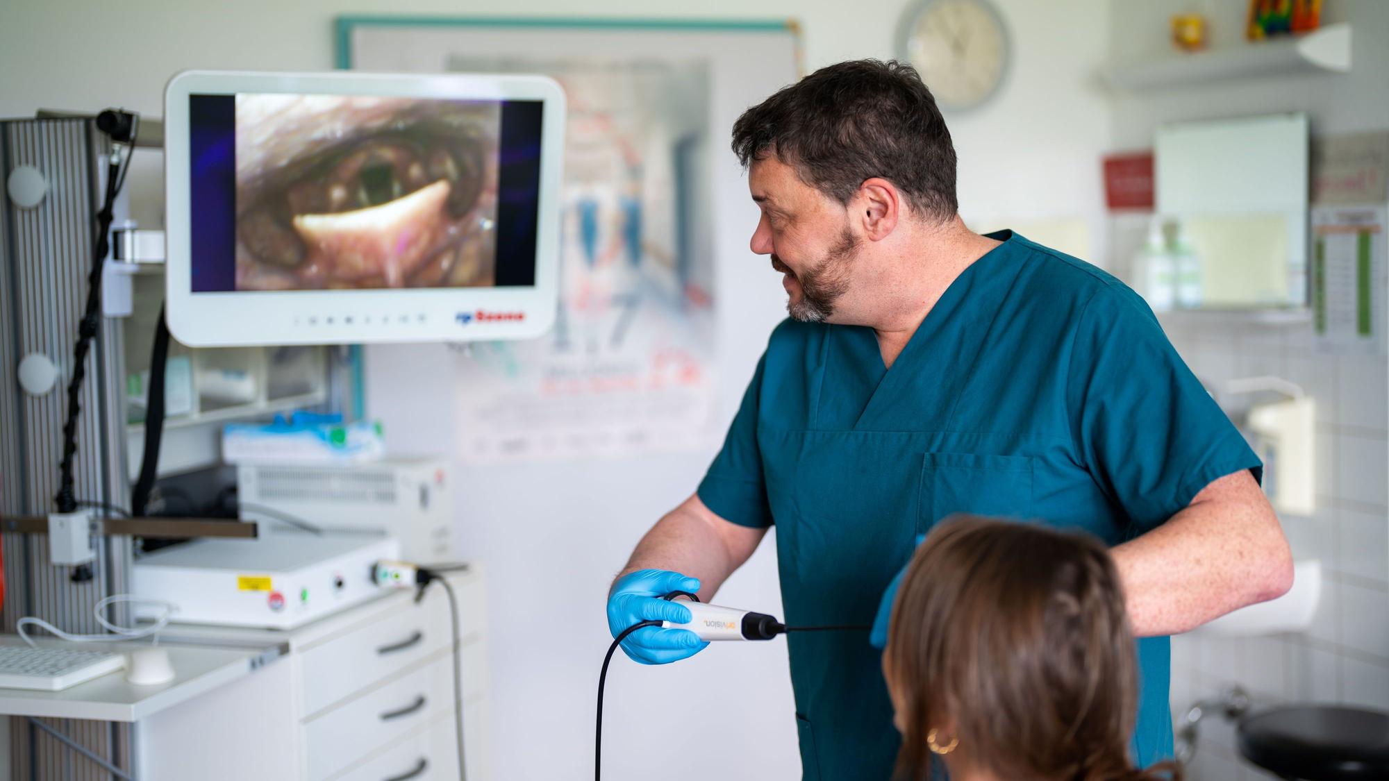Ulrich Birkmann zeigt einer Patientin live ihre endoskopische Schluckuntersuchung.