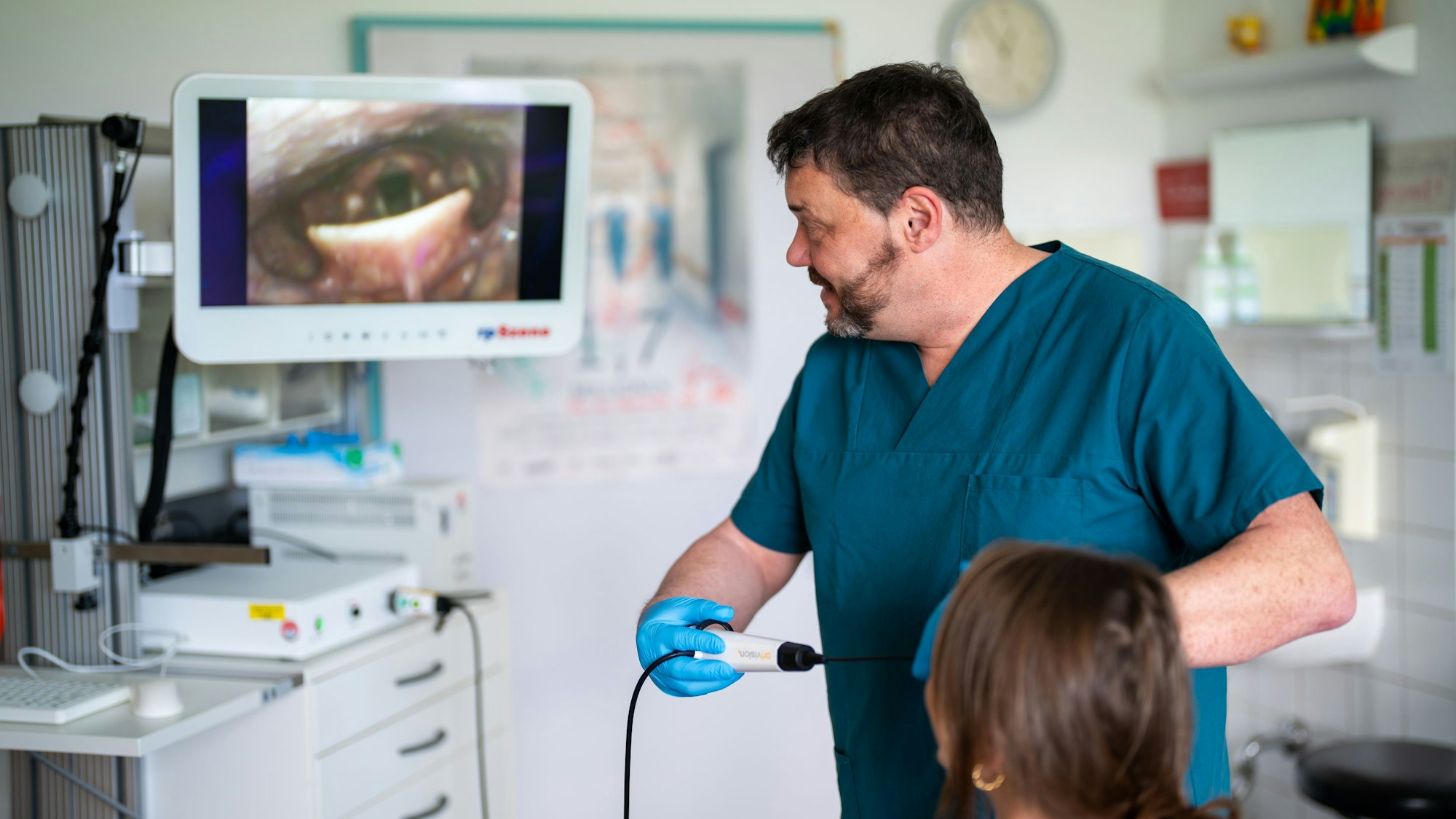 Ulrich Birkmann zeigt einer Patientin live ihre endoskopische Schluckuntersuchung.