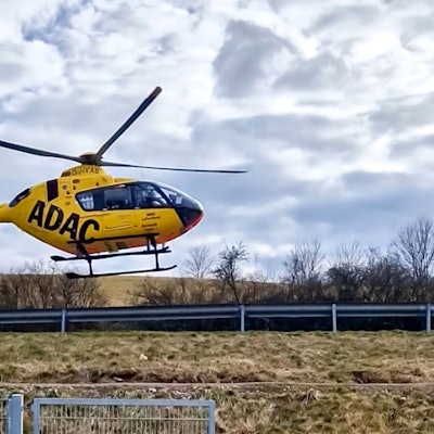 Ein Rettungshubschrauber setzt neben einem Sportplatz zur Landung an.