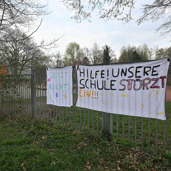 Auf dem Plakat steht: Hilfe! Unsere Schule stürzt ein.