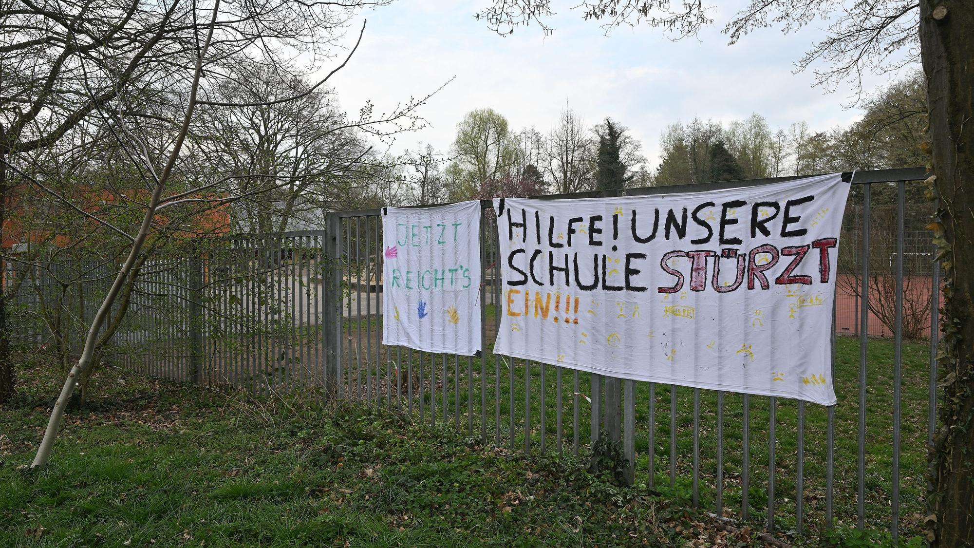 Auf dem Plakat steht: Hilfe! Unsere Schule stürzt ein.