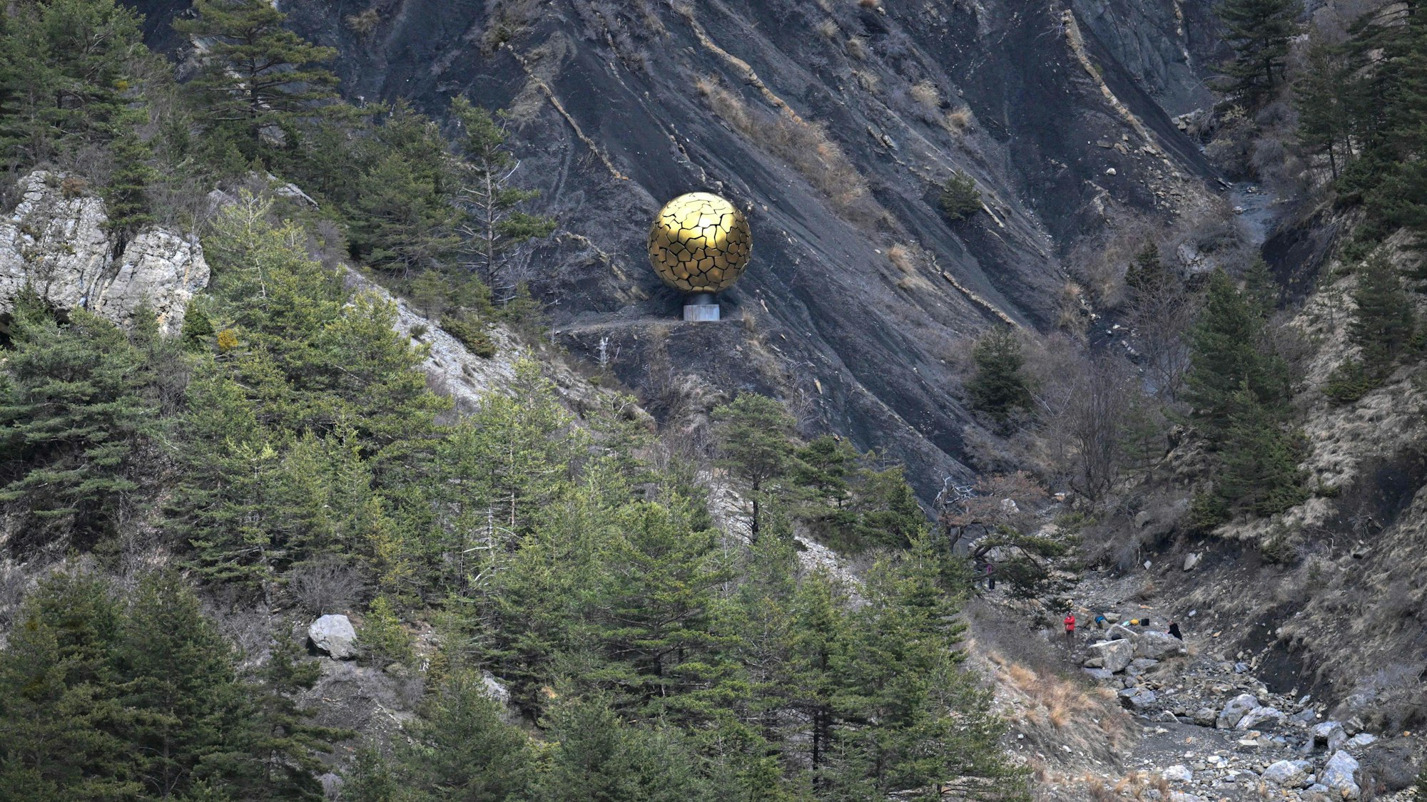 Auf dem Foto ist ein Kunstwerk zu sehen. Eine goldene Sonnenkugel erinnert an die 149 bei dem Flugzeugabsturz getöteten.